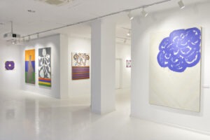 Ekspozycja wystawy "Paint and Print?". Na pierwszym planie abstrakcyjny obraz przypominający kwiat lub chmurę.