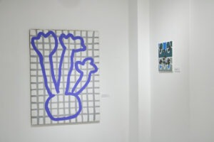 Ekspozycja wystawy "Paint and Print?". Na ścianie obraz przedstawiający obiekt przypominający kwiaty w wazonie.