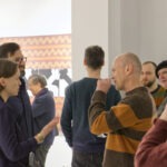 Wernisaż wystawy "Paint and Print?". Grupa ludzi rozmawia i podziwia prace.