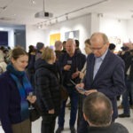 Wernisaż wystawy "Paint and Print?". Na pierwszym planie rozmawia prof. Rysiński, mężczyzna i kobieta. W tle grupa ludzi rozmawia i podziwia prace.