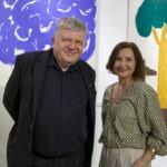 Wernisaż wystawy "Paint and Print?". W kadrze koordynatorka wystawy Magdalena Krowicka i mężczyzna. Za nimi dwa obrazy.