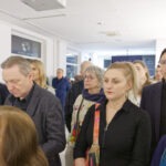 Wernisaż wystawy "Paint and Print?".Grupa ludzi słucha przemówienia artysty.