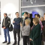 Wernisaż wystawy "Paint and Print?". W kadrze słuchający przemówienia ludzie.