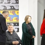 Wernisaż wystawy "Paint and Print?". Artysta prof. Rysiński rozmawia z mężczyzną. W tle abstrakcyjny obraz.