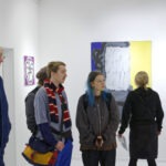 Wernisaż wystawy "Paint and Print?". Grupa ludzi podziwia prace.