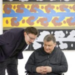 Wernisaż wystawy "Paint and Print?". W kadrze prof. Rysiński rozmawiający z mężczyzną.
