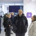 Wernisaż wystawy "Paint and Print?". W kadrze grupa rozmawiających i podziwiających prace ludzi.